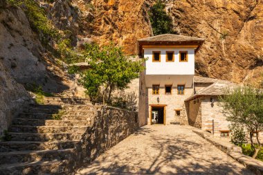 Blagaj, Bosna ve Hercegovina, 17 Ağustos 2022: Tarihi Derviş manastırı, Una Nehri 'nin bir mağaradan aktığı anıtsal bir uçuruma entegre edildi