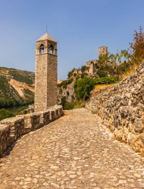 Taş saat kulesi ve tahkimatıyla tarihi Pocitelj yerleşimi, Bosna-Hersek 'in geleneksel mimarisi ve pitoresk manzarasını gösteriyor.
