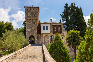 Tvrdosh Manastırı, Bosna ve Hercegovina - 20 Ağustos 2022: Tvrdos Manastırı yeşil üzüm bağının yanında ve Trebinje 'de ziyaretçilerle yürüyüş yolu.