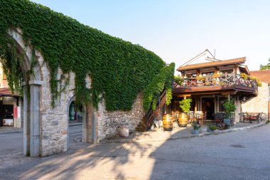 Trebinje, Bosna ve Hercegovina - 21 Ağustos 2022: Trebinje şehir binaları ve açık mavi gökyüzü altındaki yeşil ağaçlar.