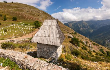 Bosna-Hersek 'in tarihi Lukomir köyü mezarlığına bakan dağ yamacında ahşap çatılı geleneksel taş ev.