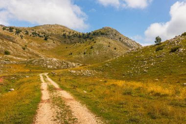 Engebeli bir dağ vadisinde dolambaçlı toprak yol, el değmemiş vahşi doğayı gözler önüne seriyor ve Bosna-Hersek 'te keşiflere davetiye çıkarıyor..