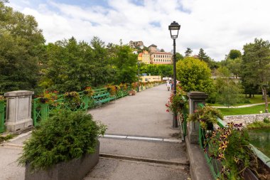 Jajce, Bosna ve Hercegovina - 25 Ağustos 2022: Pliva nehri eski binalar, ağaçlar ve taş duvarların önünden geçiyor.