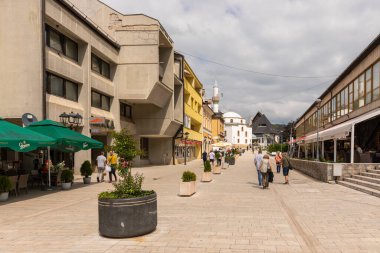 Jajce, Bosna ve Hercegovina - 25 Ağustos 2022: Bosna-Hersek 'in Jajce kentinde tarihi sokak sahnesi, bir bina ve bir cami gösteriliyor.