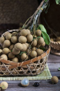 Fresh longan fruit in the basket on the rustic wooden table