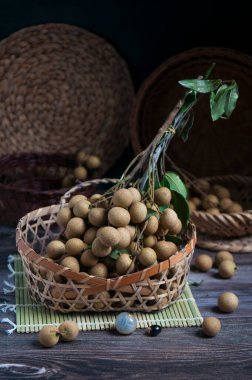 Fresh longan fruit in the basket on the rustic wooden table
