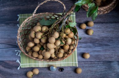 Fresh longan fruit in the basket on the rustic wooden table