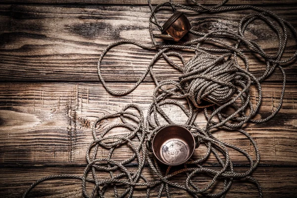 Rope and copper utensils on old wooden burned table or board for — Stock Photo, Image