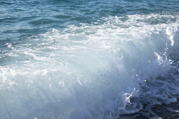 Welle auf der Kieselküste des Meeres. Selektiver Fokus — Stockfoto