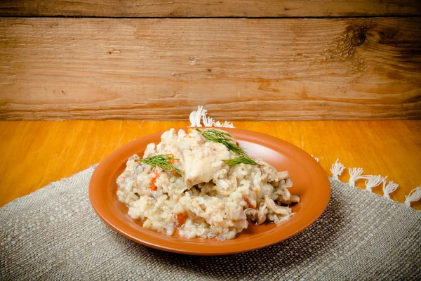 Reis mit Huhn auf einem Tonteller auf Leinenserviette. gemildert — Stockfoto