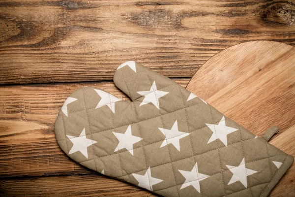 Round cutting board and pot holder on old wooden burned table or — Stock Photo, Image