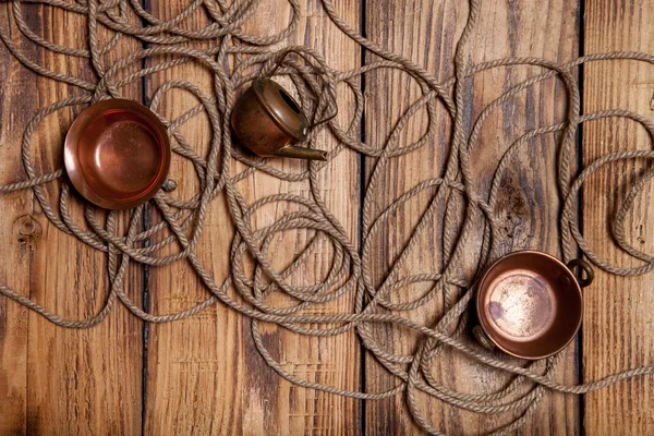 Rope and copper utensils on old wooden burned table or board for — Stock Photo, Image