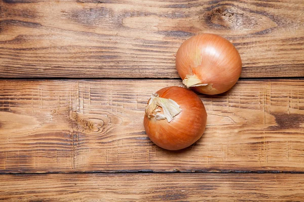 Oignon frais sur une vieille table ou une planche brûlée en bois pour le fond — Photo