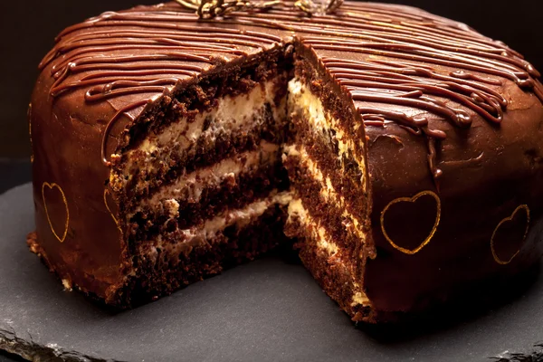 Schokoladenkuchen auf Schieferteller auf schwarzem Hintergrund — Stockfoto