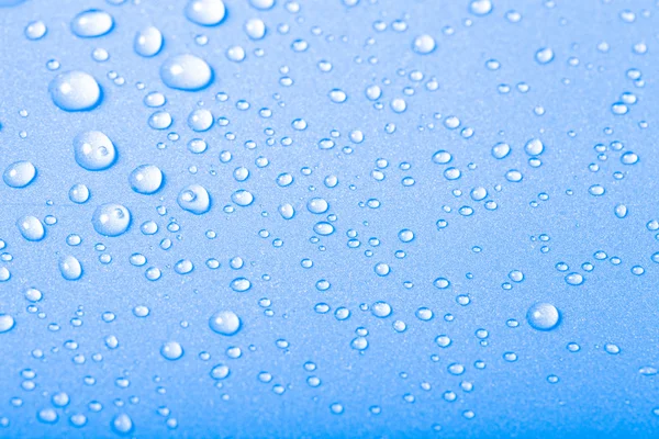 Gotas de agua sobre un fondo de color. Azul. Profundidad superficial de fie —  Fotos de Stock