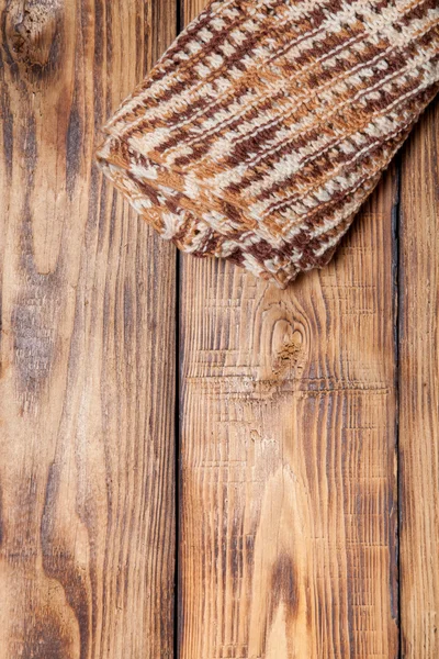 Écharpe tricotée sur une vieille table ou une planche brûlée en bois pour le fond — Photo