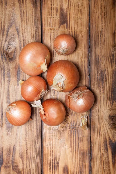 Oignon frais sur une vieille table ou une planche brûlée en bois pour le fond — Photo