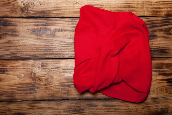 Red kitchen towel on old wooden burned table or board for backgr — Stock Photo, Image