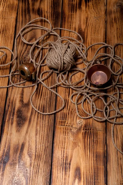 Rope and copper utensils on old wooden burned table or board for — Stock Photo, Image