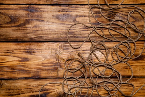 Rope on old wooden burned table or board for background. Toned — Stock Photo, Image