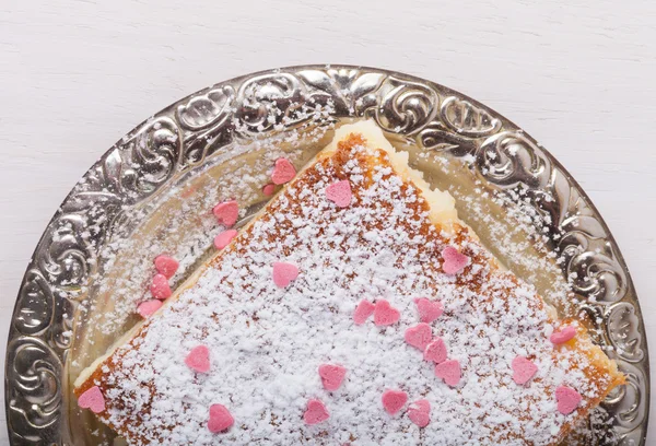 Homemade cake on a metal plate on colored wooden background — Stock Photo, Image