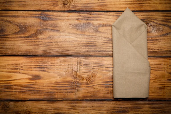 Napkin on old wooden burned table or board for background. Toned — Stock Photo, Image