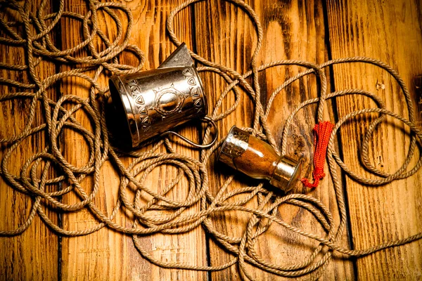 Corde, épices et ustensiles métalliques sur une vieille table en bois brûlé ou bo — Photo
