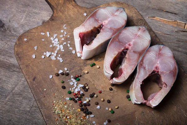 Roher Thunfisch und Gewürze zum Kochen auf altem Holzgrund — Stockfoto