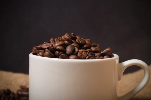 カップ、ソーサー、黄麻布の背景にコーヒー豆。浅い dep — ストック写真