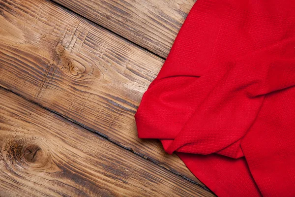 Red kitchen towel on old wooden burned table or board for backgr — Stock Photo, Image