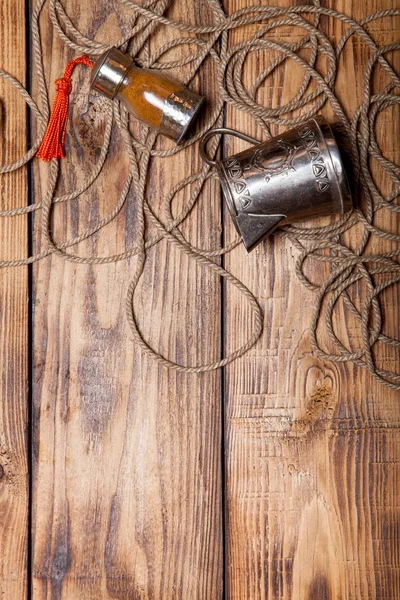 Corda, especiarias e utensílios de metal na velha mesa queimada de madeira ou bo — Fotografia de Stock