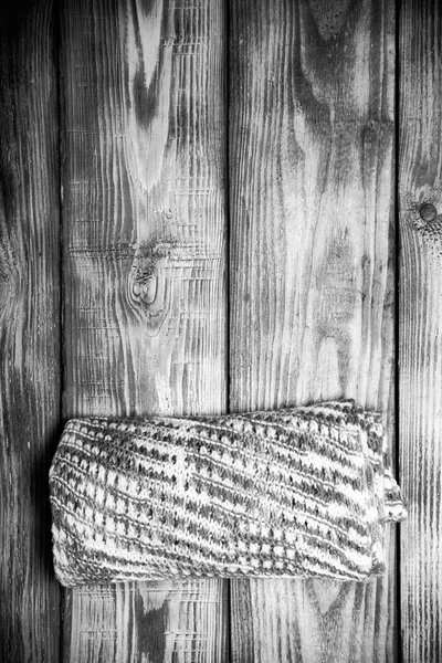 Knitted scarf on old wooden burned table or board for background — Stock Photo, Image