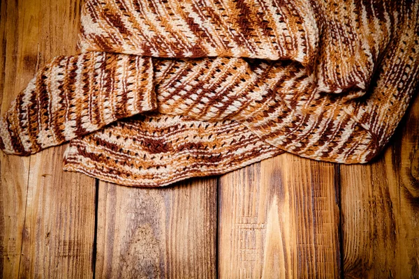 Knitted scarf on old wooden burned table or board for background — Stock Photo, Image