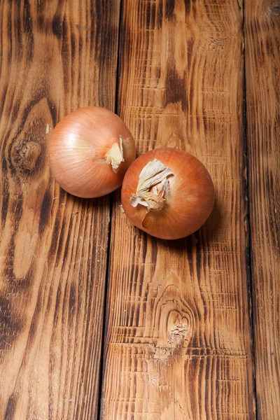Fresh onion on old wooden burned table or board for background — Stock Photo, Image
