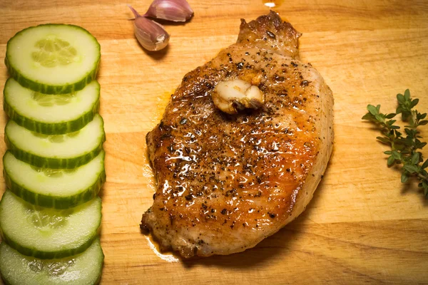 Свіже смажене м'ясо з чебрецем, часником та огірком на легкому дерев'яному — стокове фото