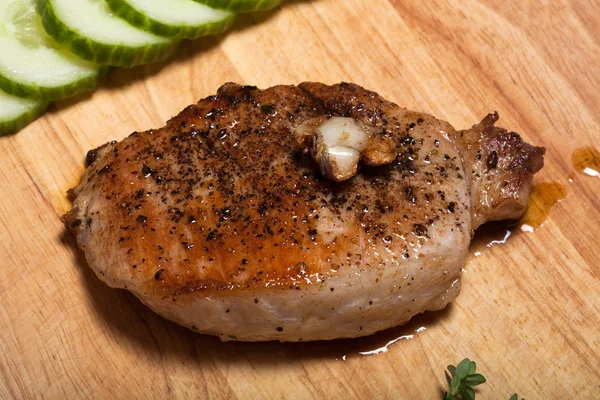 Fresh fried meat with thyme, garlic and cucumber on light wooden — Stock Photo, Image