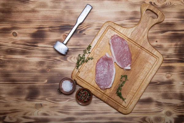 Bifes de carne fresca na placa de corte de madeira leve — Fotografia de Stock