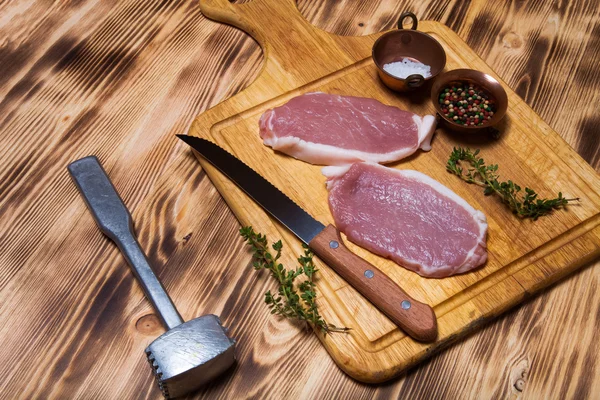 Bistecche di carne fresca su tagliere di legno leggero. Tonica — Foto Stock