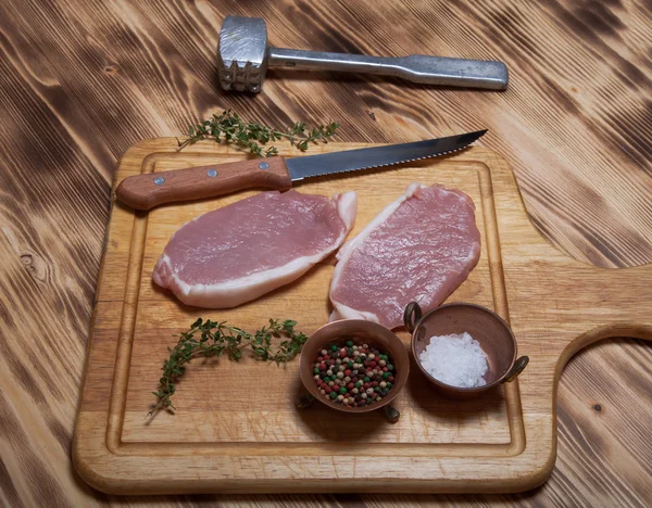 Bistecche di carne fresca su tagliere di legno leggero — Foto Stock