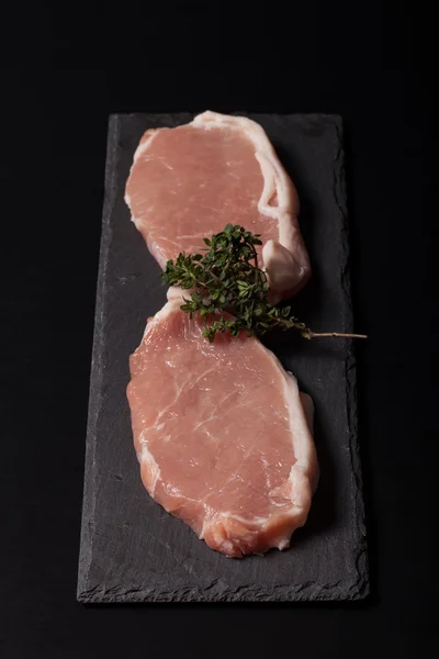 Bistecche di carne fresca su sfondo nero ardesia. Focus selettivo — Foto Stock