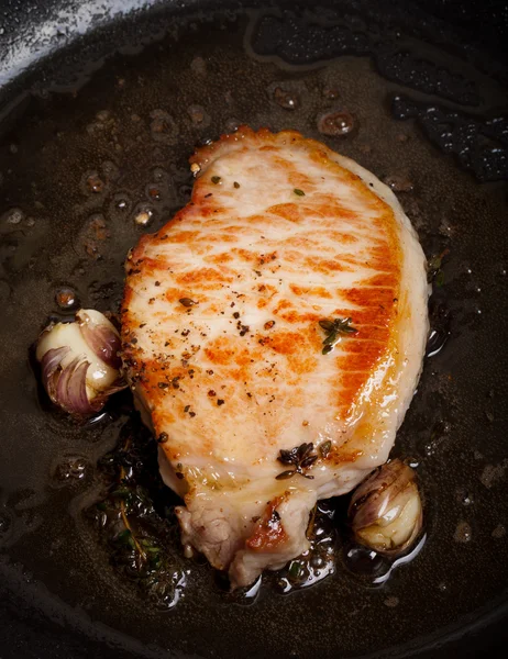 Fresh meat is fried in a frying pan with thyme and garlic. Selec — Stock Photo, Image