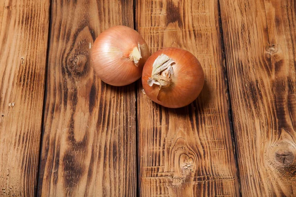 Fresh onion on old wooden burned table or board for background — Stock Photo, Image
