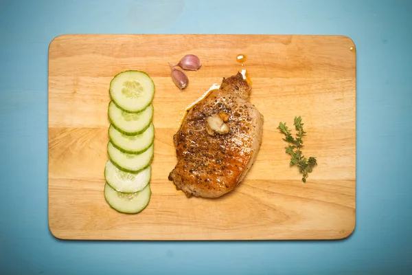 Carne fritta fresca con timo, aglio e cetriolo su legno chiaro — Foto Stock