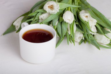 Fincan çay ve demet bahar Lale masanın üzerinde. Sığ bölümü