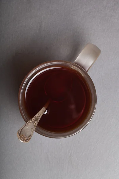 Tasse de thé noir avec cuillère melchior sur table en ardoise noire. Haut v — Photo