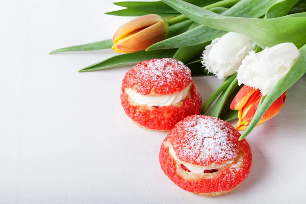 Bolos caseiros de creme com creme e um monte de tulipas de primavera em — Fotografia de Stock