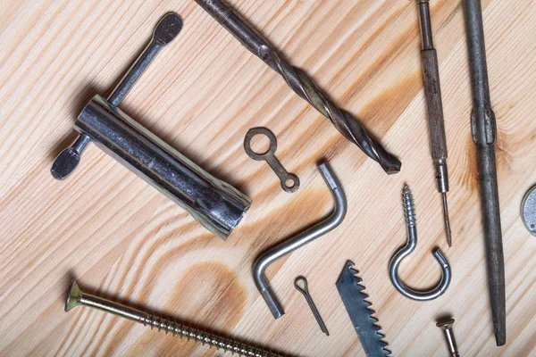 The contents of the old toolbox on light wooden background. Top