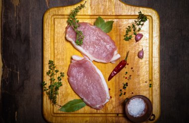 Hafif ahşap kesme tahtası üzerinde taze et biftek. Tonda