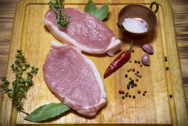 Bistecche di carne fresca su tagliere di legno leggero. Tonica — Foto Stock