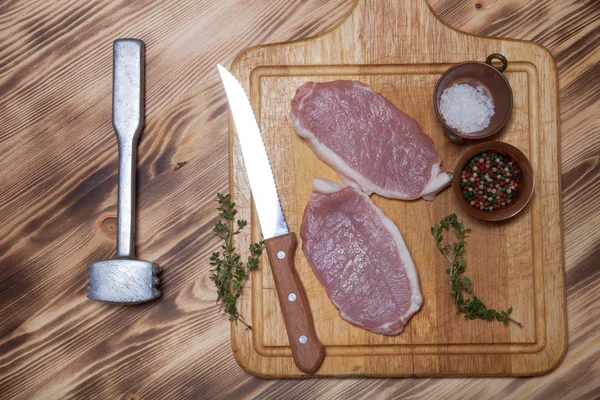 Bistecche di carne fresca su tagliere di legno leggero — Foto Stock